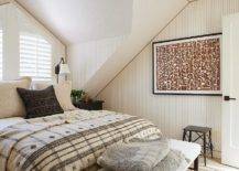 Bedroom features a queen bed in front of shuttered windows and brown art on brown striped wallpaper.