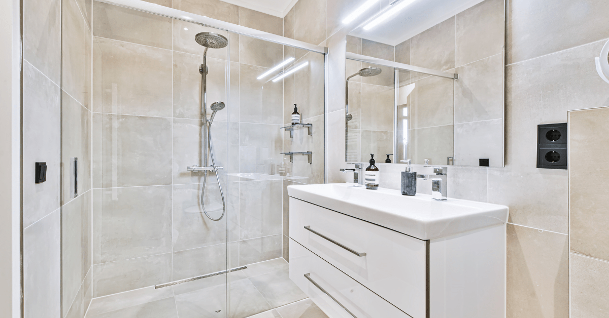 White wet room bathroom with stainless steel fixtures and shower.